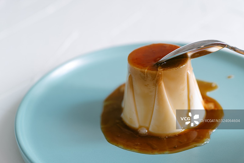 用勺子舀奶酪布丁的不知名人士特写图片素材