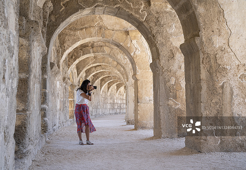 在土耳其安塔利亚阿斯潘多斯圆形剧场拍照的女游客图片素材