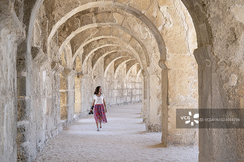 在土耳其安塔利亚阿斯潘多斯圆形剧场拍照的女游客图片素材
