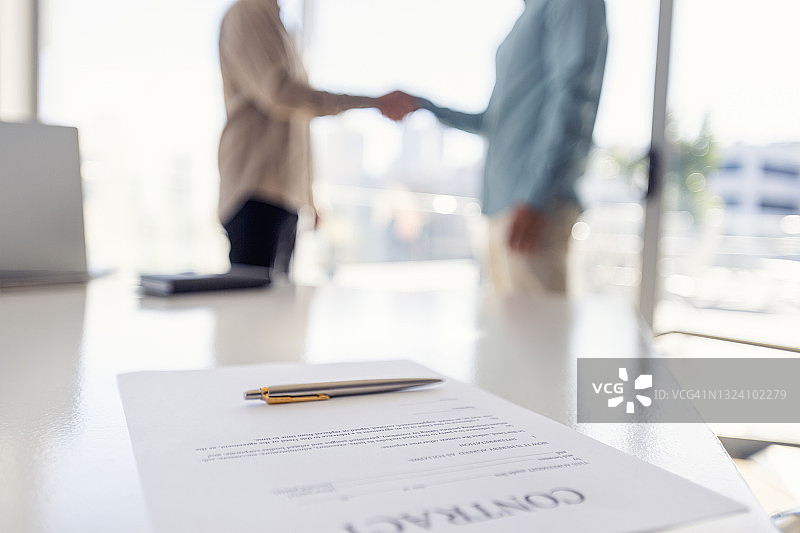 两位商人手持合同握手图片素材