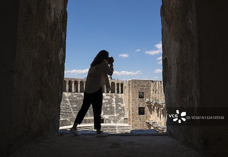 年轻女子在古代阿斯潘多斯罗马剧院旅行图片素材