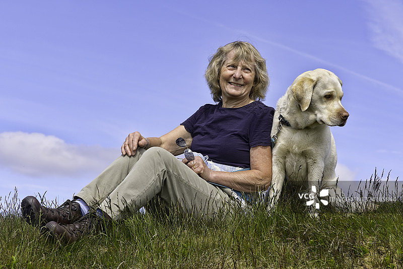 年长女士遛狗时休息图片素材