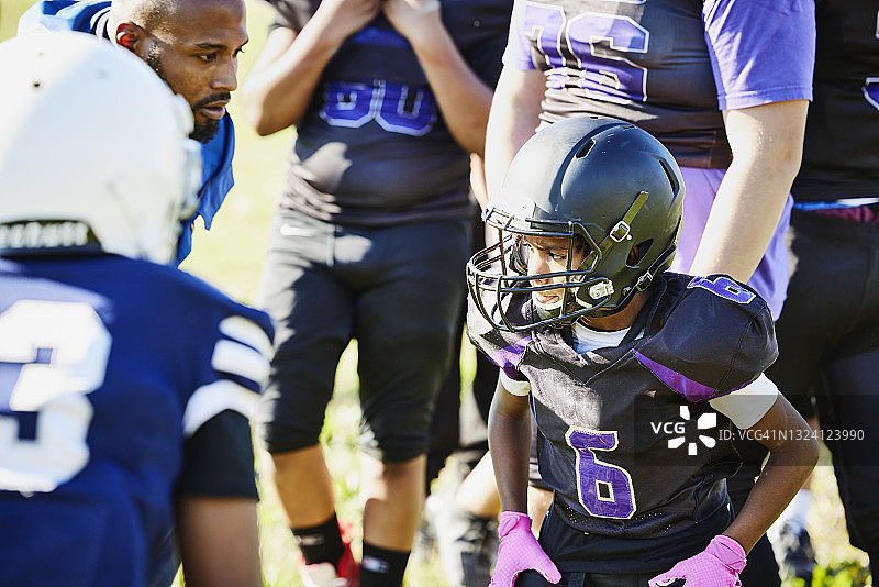 年轻的足球运动员在秋季下午的足球训练中准备跑步图片素材