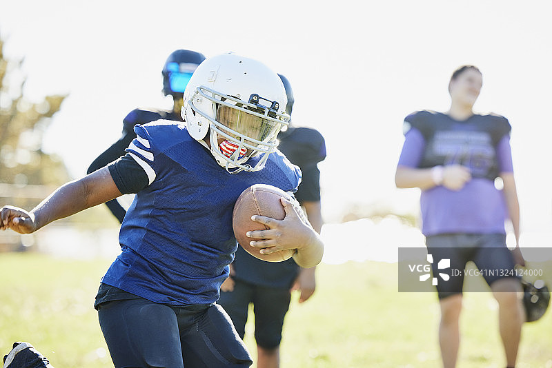 秋日下午，年轻足球运动员带球奔跑图片素材