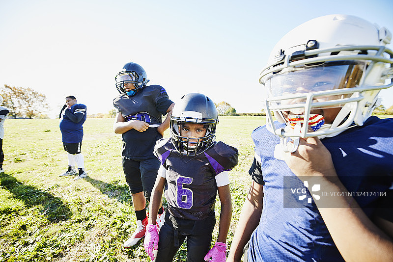 秋日下午足球训练中看向镜头的年轻足球运动员中景肖像图片素材