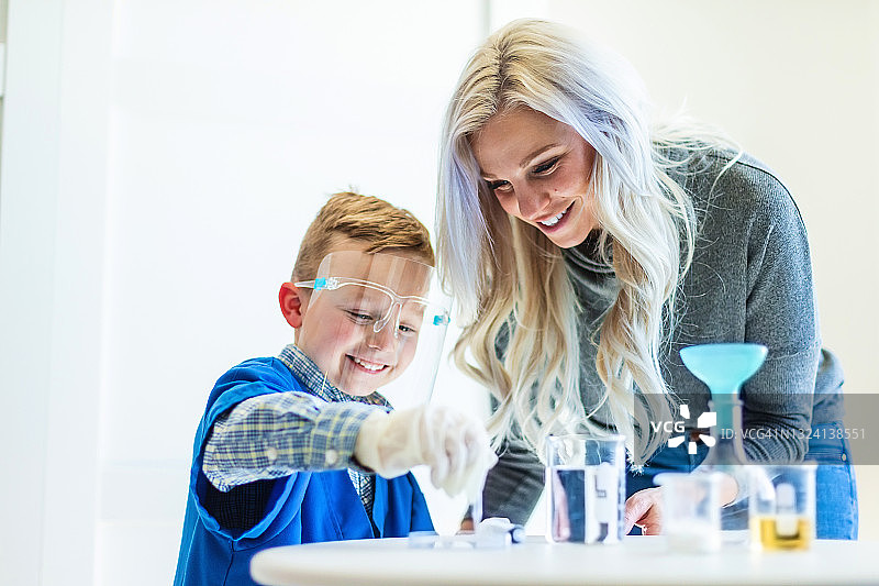 千禧一代母亲与学龄前儿子在家进行远程科学实验照片系列图片素材