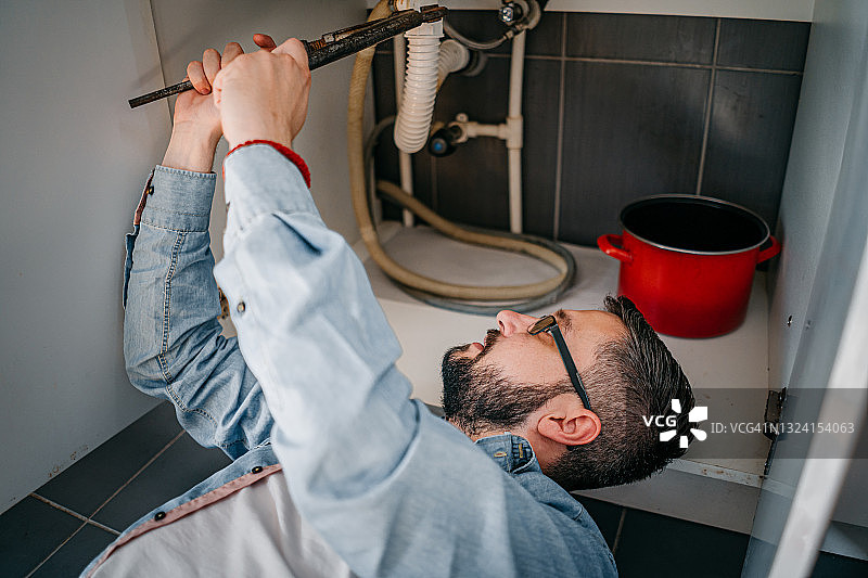 男水管工修理漏水水槽图片素材