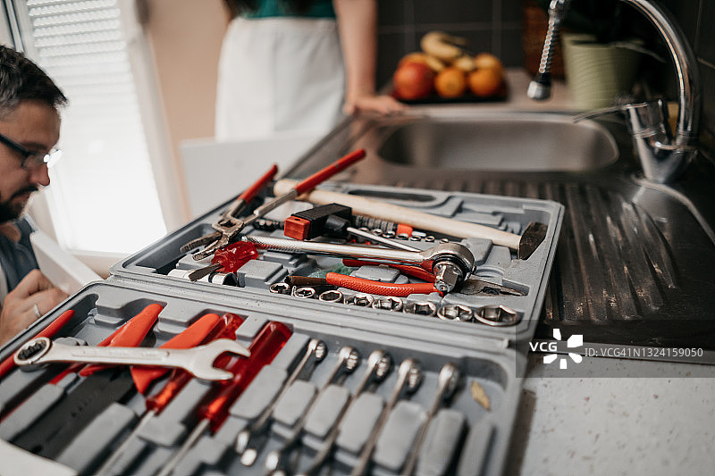 厨房管道损坏问题，女人和修理工图片素材