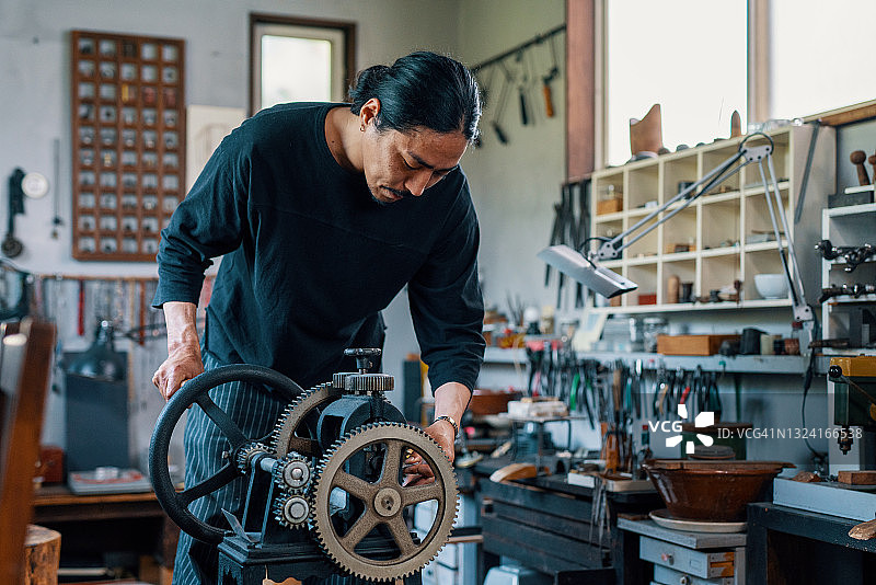 中年银匠准备银片以制作珠宝图片素材
