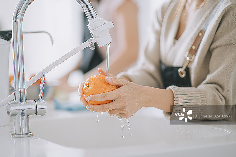 亚洲女人在家清洗橘子图片素材