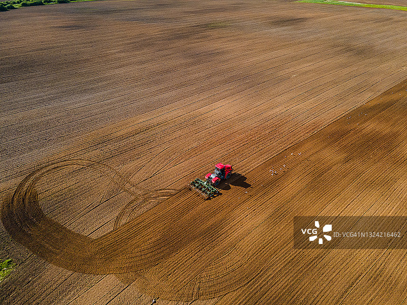 时令土地耕作：农业拖拉机田间作业航拍图片素材