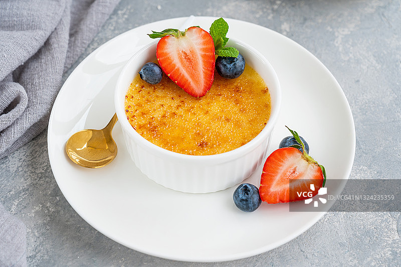 焦糖布丁：传统法式香草奶油甜点，配焦糖和新鲜浆果图片素材