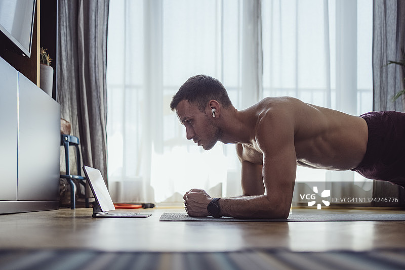 居家锻炼：年轻男子在家锻炼图片素材