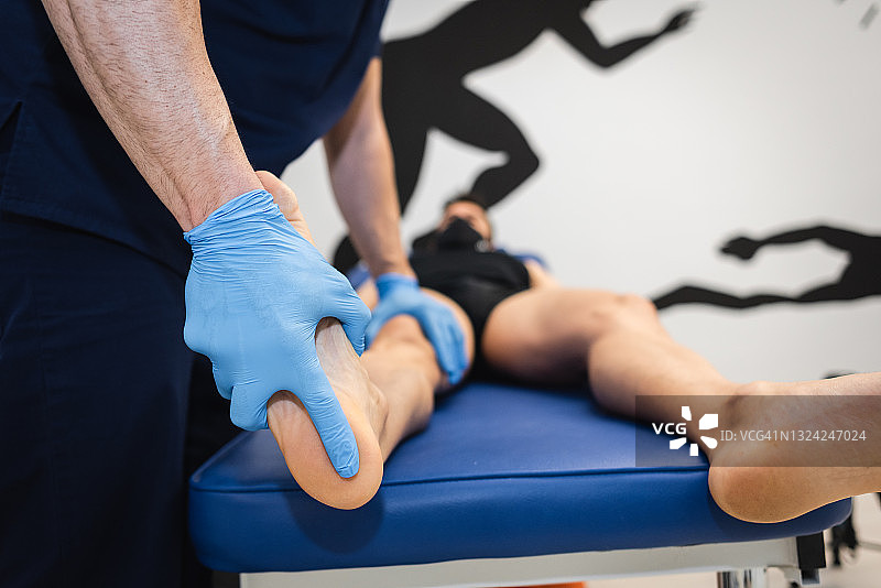 足病医生在担架上检查病人的脚图片素材