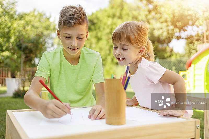 女孩看着她的哥哥画画图片素材