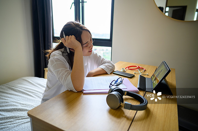 一位疲惫不堪的年轻女商人，在电脑上完成大量工作后，感到眼睛疼痛图片素材
