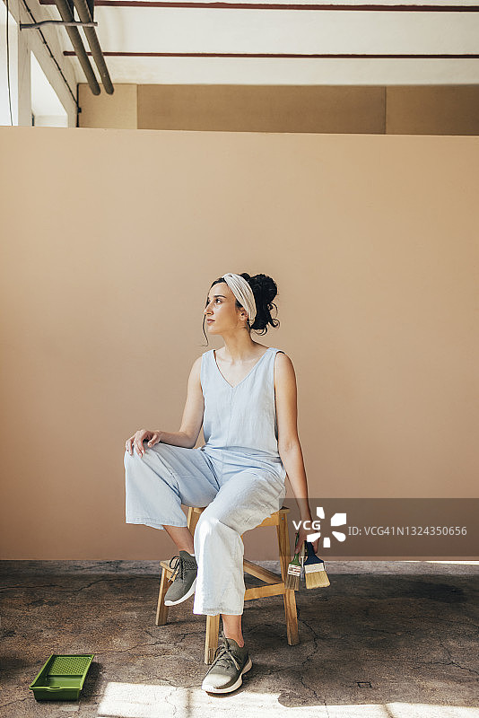 坐在椅子上手持画笔的漂亮女人图片素材