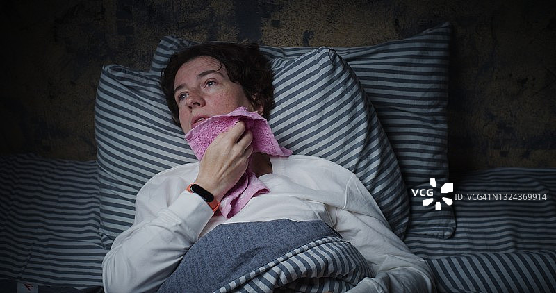 中年妇女在床上因炎热难以入睡图片素材