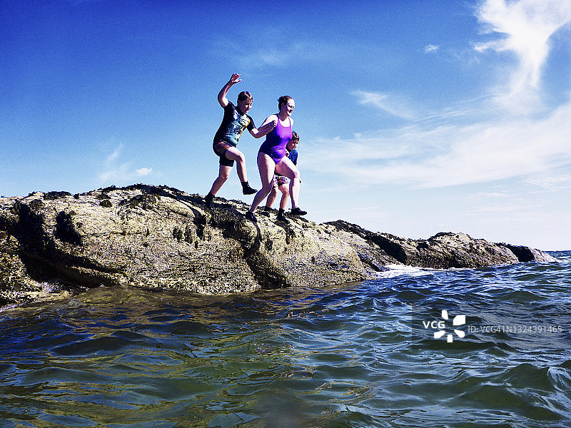 女人和孩子们跳入大海图片素材