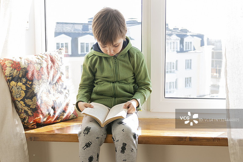 可爱的男孩在家读书图片素材