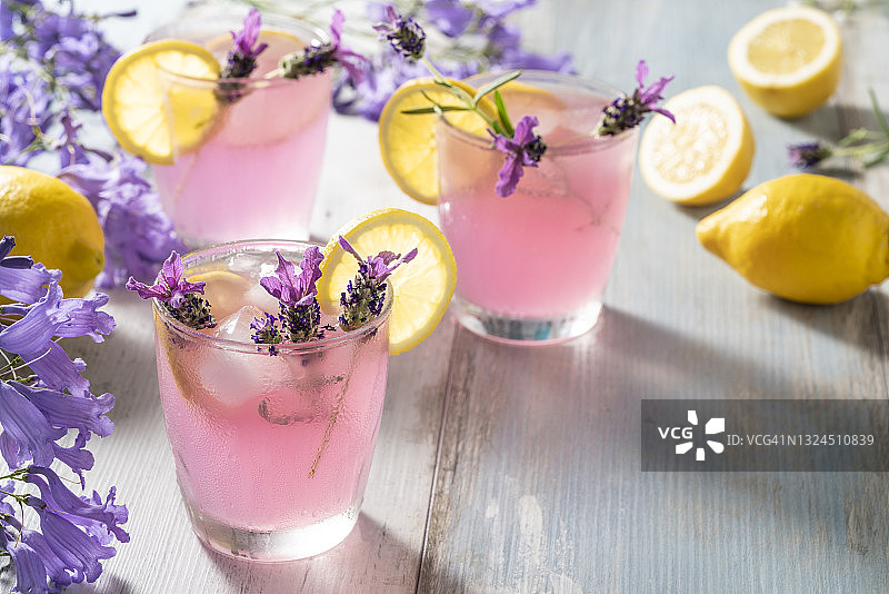 粉色柠檬水，注入薰衣草花，冰块和柠檬片在柔和的彩色背景中图片素材