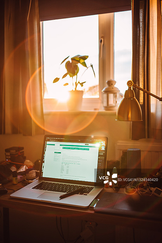 家居办公室一角：打开的笔记本电脑放置在家庭书房的桌子上图片素材