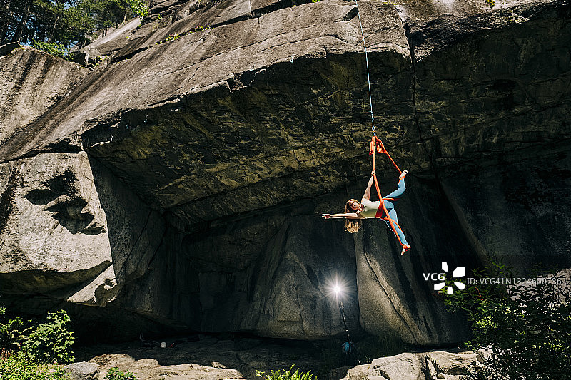空中杂技演员在悬崖下的丝绸上表演图片素材