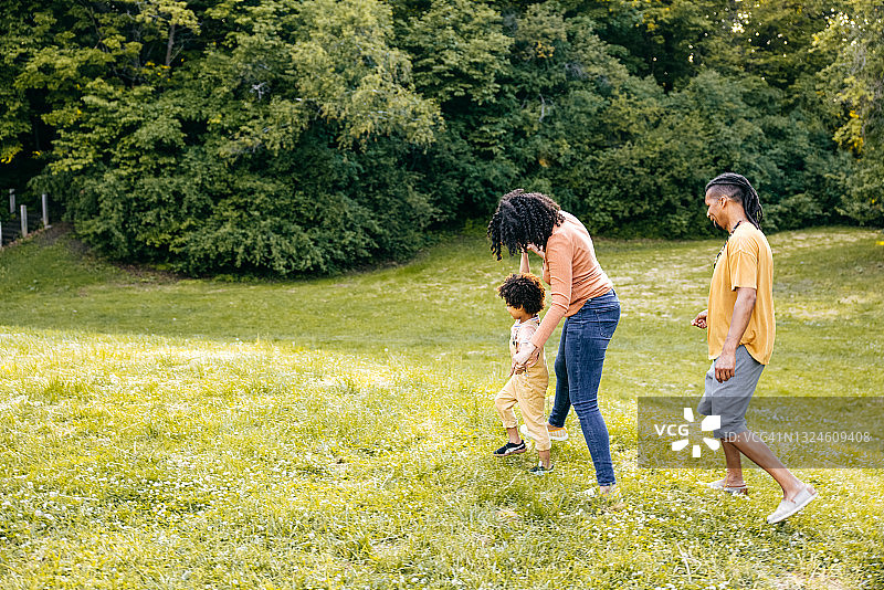 夏日：幸福的三口之家在公园散步图片素材