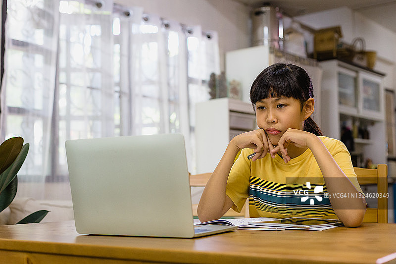疲惫的亚洲女孩在家学习，进行远程教育图片素材