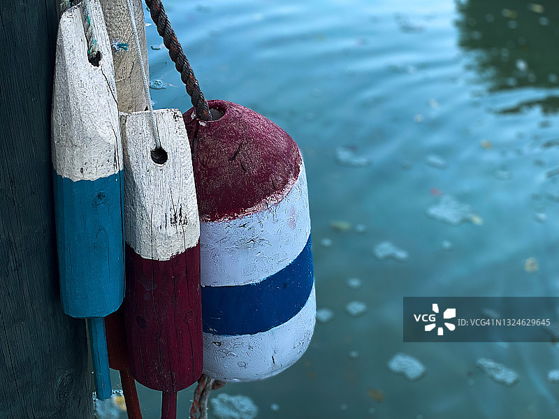 码头柱子上悬挂的一组古董龙虾浮标图片素材