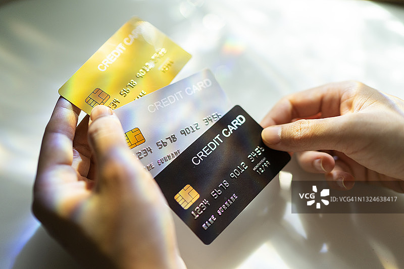 手持黑色、金色、铂色信用卡特写图片素材