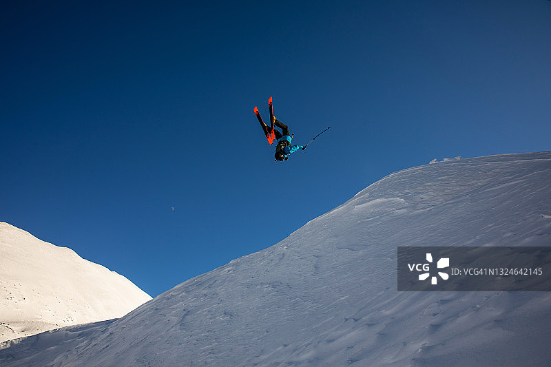 自由滑雪者在山区后空翻图片素材