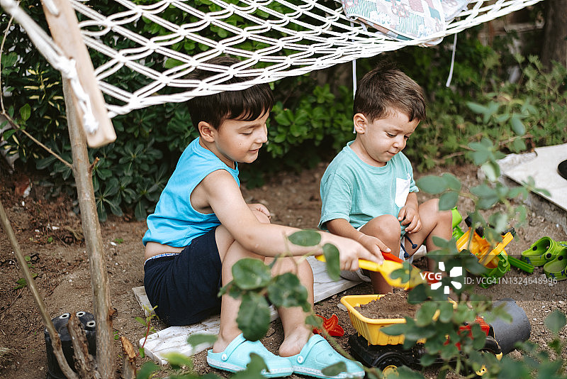 两个可爱的小朋友在花园里玩耍图片素材
