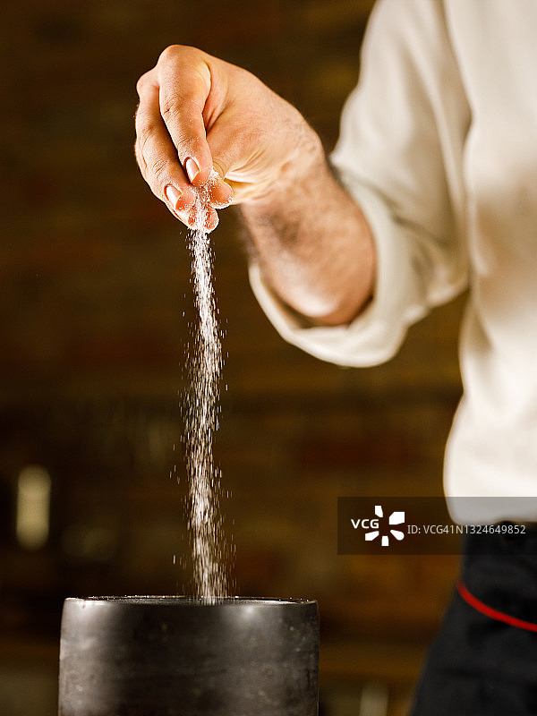 厨师在菜谱中加盐的特写镜头图片素材