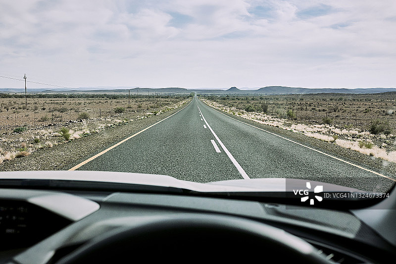 透过挡风玻璃看通往地平线的沙漠公路图片素材
