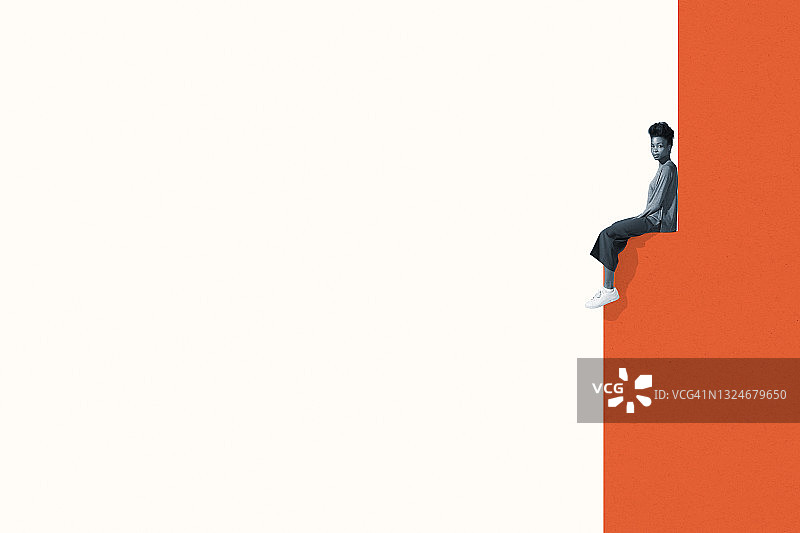 坐在橙色墙前的年轻女子图片素材