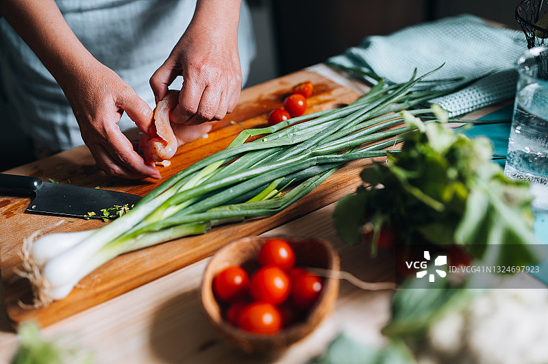 女人在木板上切割白色肉类图片素材