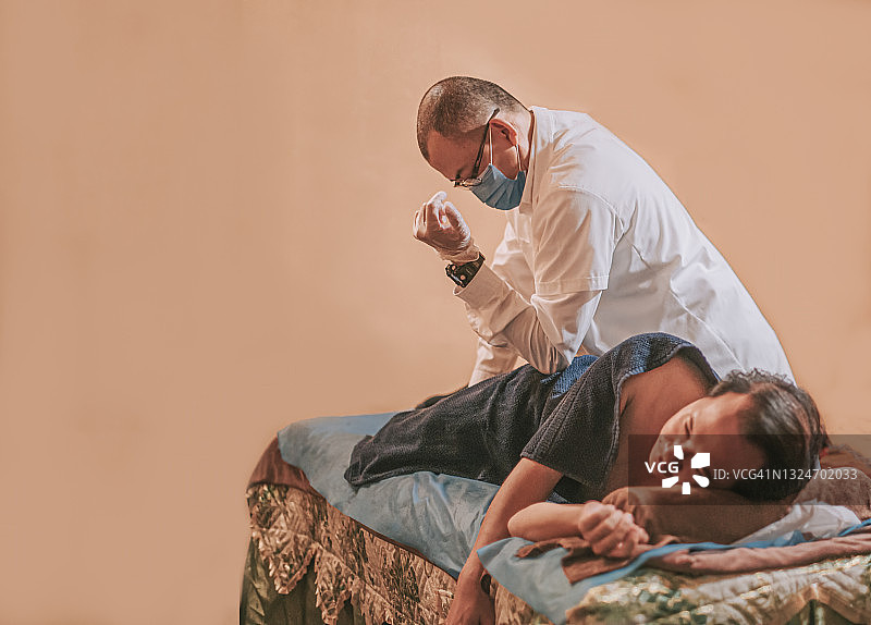 亚洲男按摩治疗师用肘部力量在男病人身上进行指压按摩图片素材