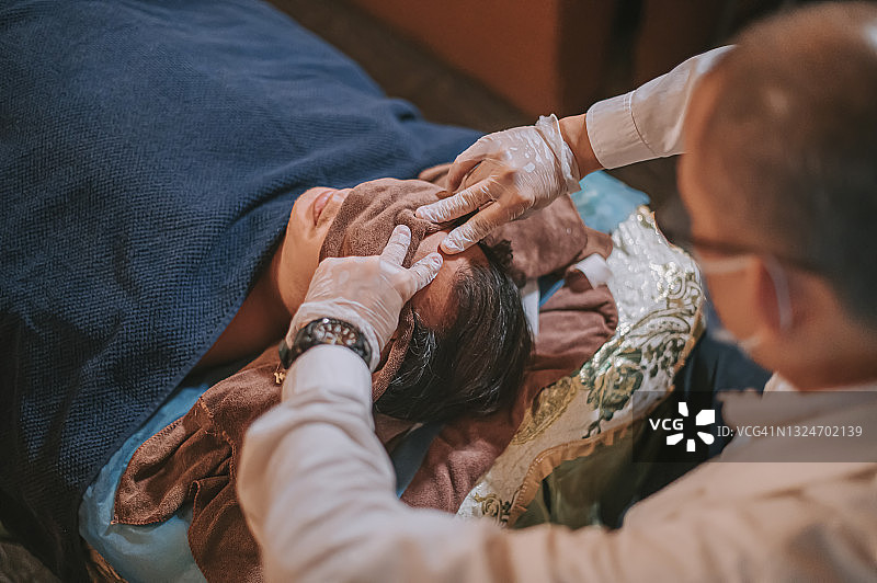 亚洲男性按摩师指压患者头部穴位缓解压力俯视图图片素材