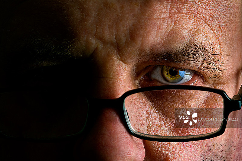 眼镜后男人眼睛的阴郁特写图片素材