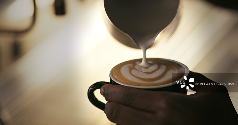 咖啡师在卡布奇诺中创作咖啡拉花艺术图片素材