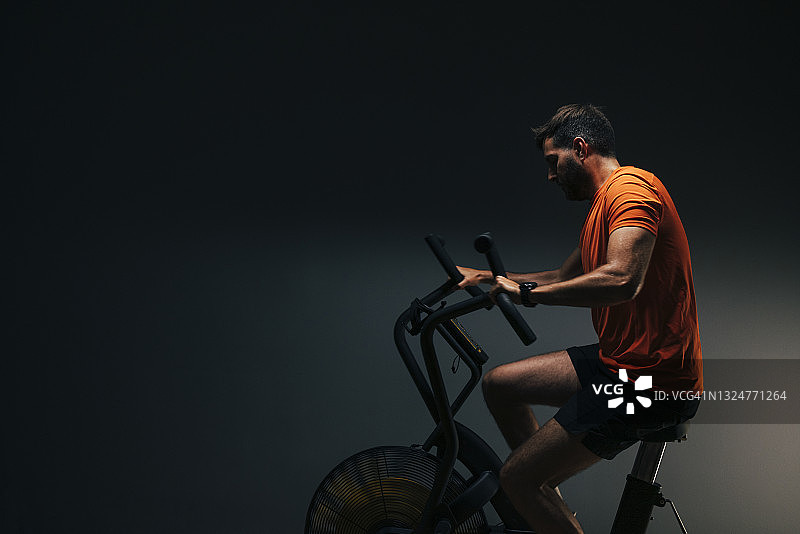 在健身车上锻炼的英俊运动员图片素材