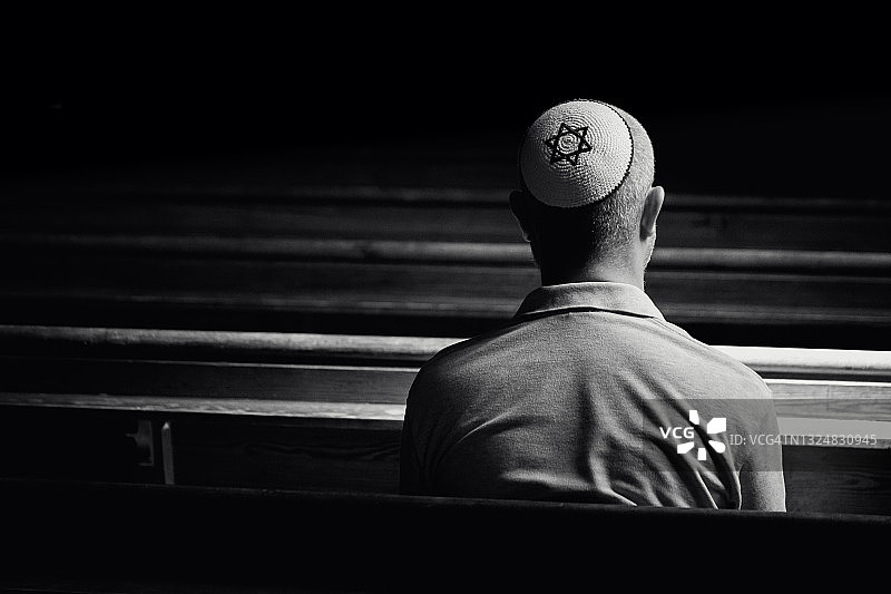 戴着小圆帽在犹太教堂内祈祷的年轻男人图片素材