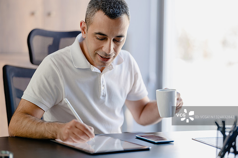 男人在办公室使用数位平板电脑和智能手机图片素材