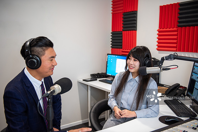 年轻的亚洲女性主持人在广播工作室采访年轻男子图片素材