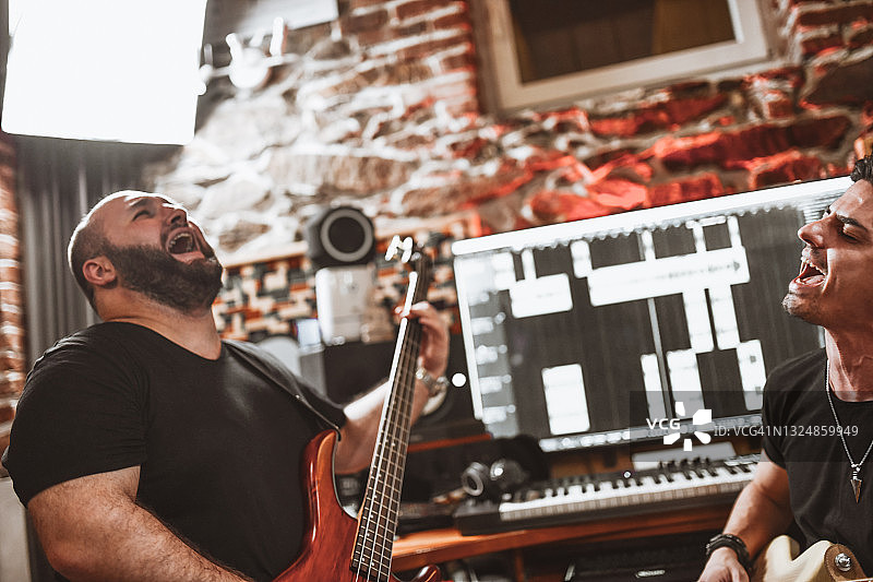 贝斯手和吉他手在录音室一起感受歌曲的节奏图片素材
