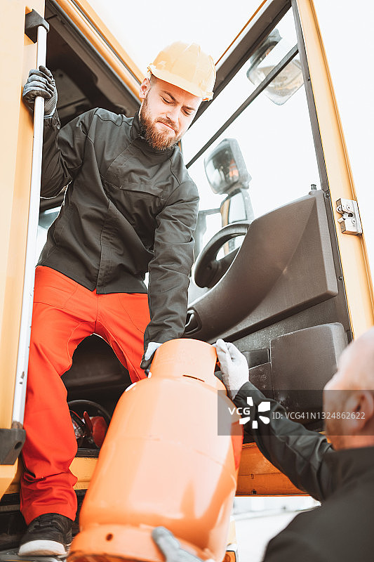 油罐车司机在驾驶舱内携带煤气罐图片素材