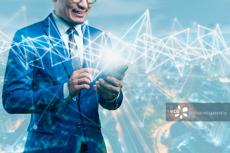 商人指向智能手机上的数字全息图，数字化转型、物联网和技术概念图片素材