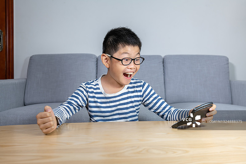 聪明的男孩在使用计算器并欢呼图片素材