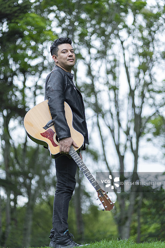 音乐家肖像：吉他演奏者看向镜头图片素材